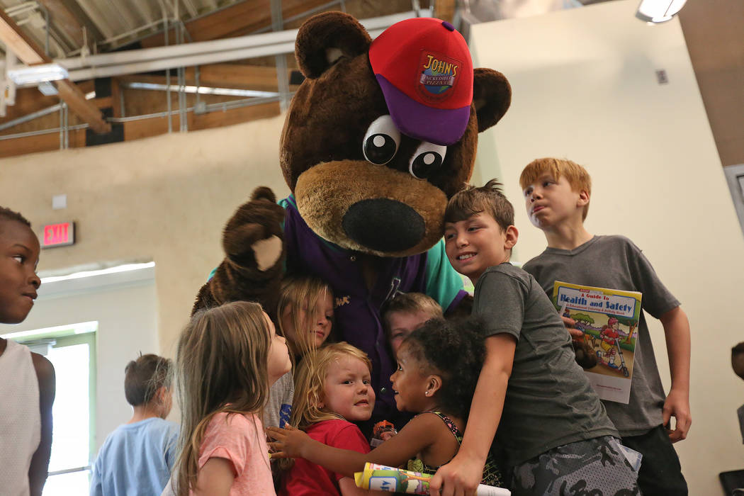 Incredibear from John's Incredible Pizza Company hugs kids at the annual Back to School Fair organized by the Happy Face Foundation at Springs Preserve in Las Vegas, Sunday, Aug. 5, 2018. Students ...