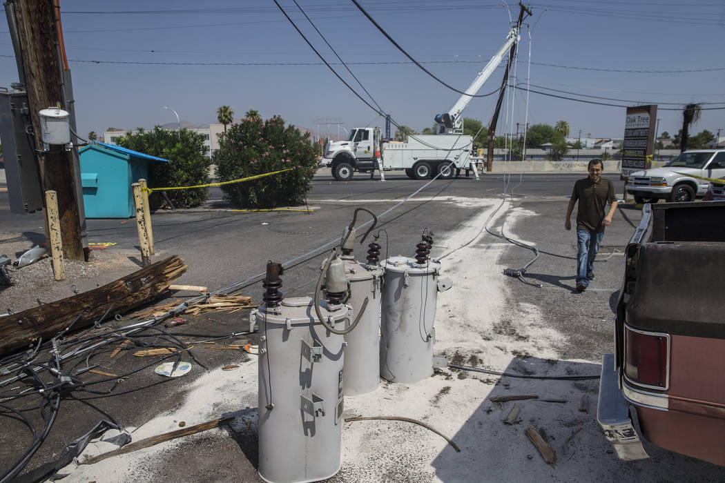 Las Vegas residents pass by NV Energy crews working to restore power in the area of Fremont Street and Bruce Street on Sunday, Aug., 12, 2018, in Las Vegas. More than 60,000 people lost power Satu ...
