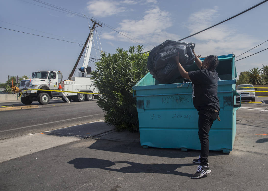 711 cashier Gilda Cook throws out produce that was lost after power was knocked out at the convenience store on Fremont Street and Bruce Street on Sunday, Aug., 12, 2018, in Las Vegas. More than 6 ...