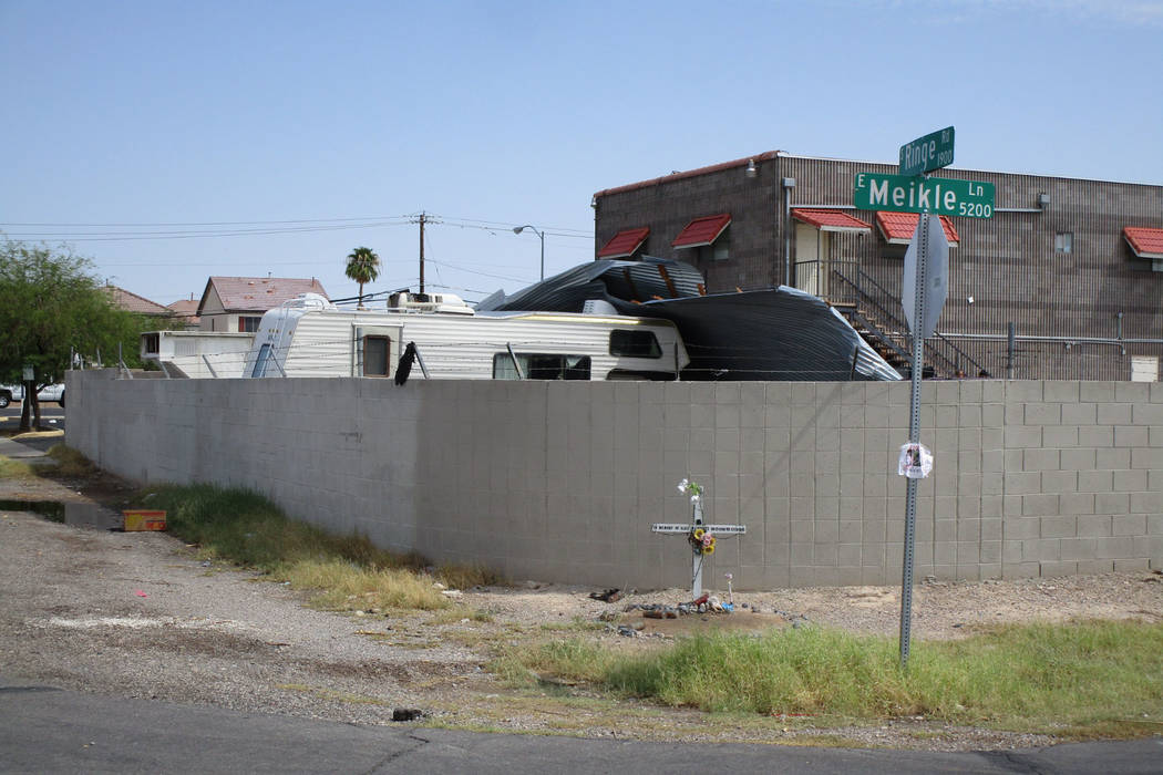Workers try to dismantle a sheet metal awning that collapsed in Saturday night’s storm behind a business in east Las Vegas near Lake Mead Boulevard and Nellis Boulevard on Sunday, August 12, 201 ...