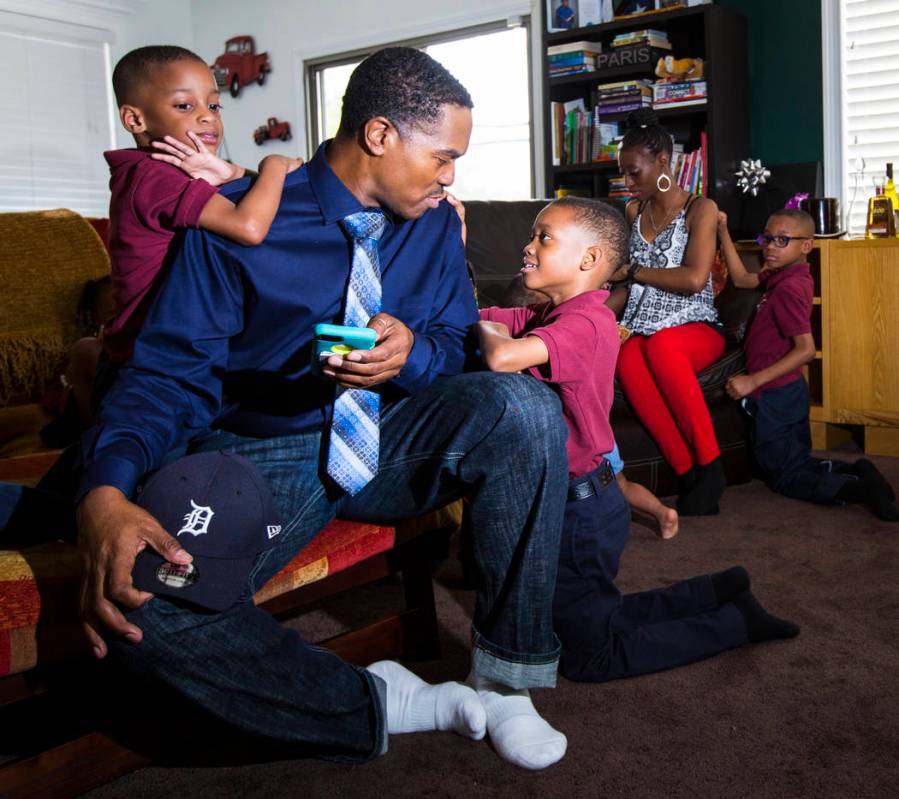 Deon Derrico sits with his children, Deniko, 4, left, and Denver, 6, at their home in North Las ...