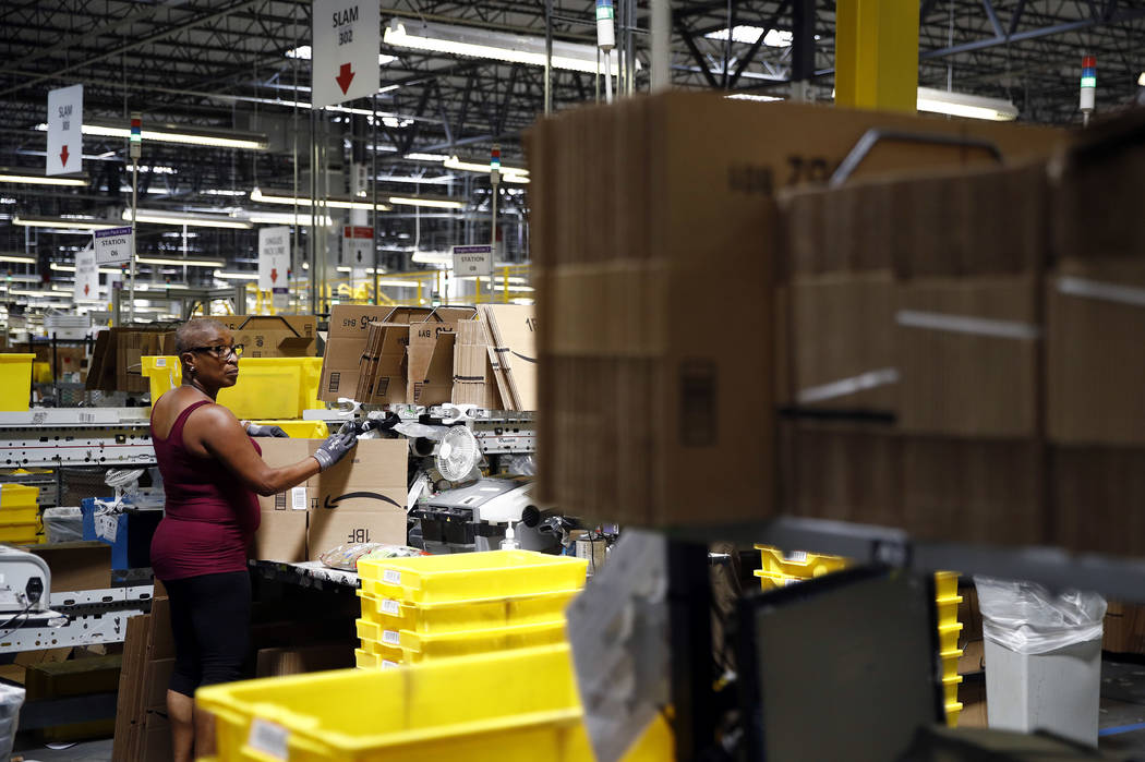 Cynthia Richburg prepares a product for shipment at an Amazon fulfillment center in Baltimore, ...