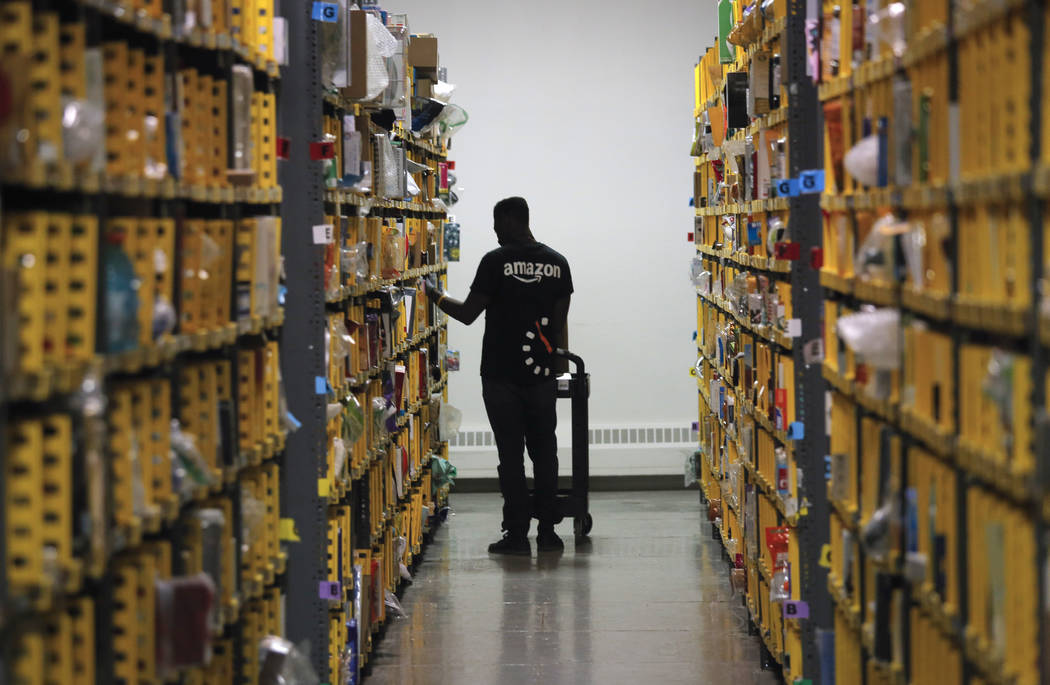 An employee of Amazon PrimeNow stacks shelves for customers making last minute holiday orders a ...