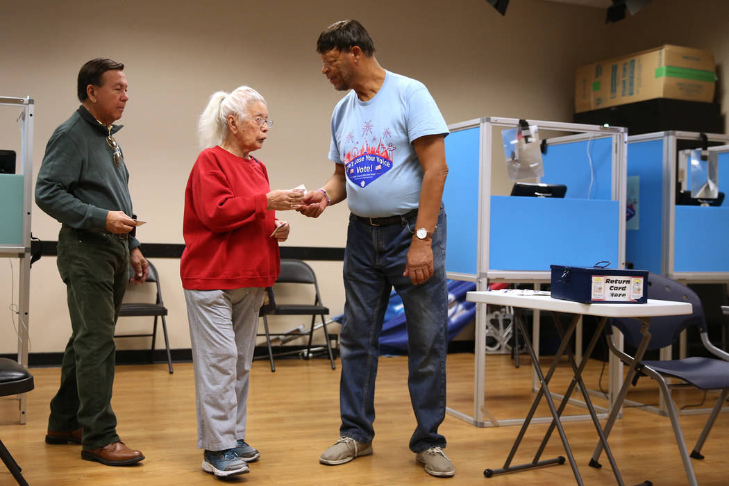 Voters Rudy De Leon and Esther French receive "I Voted" stickers from poll worker Myron Wilson at the East Las Vegas Community Center in Las Vegas, Saturday, Oct. 20, 2018. Erik Verduzco Las Vegas ...