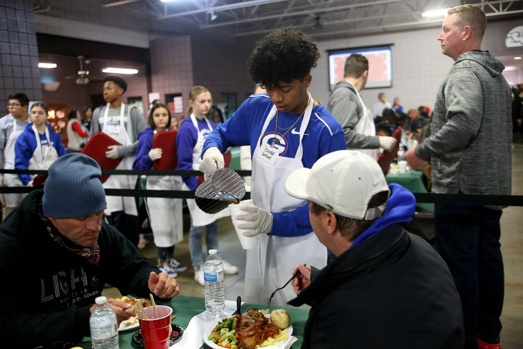 Jovani Hawkins, 17, serves coffee to guests at the Christmas meal sponsored by the Frank and Victoria Fertitta Foundation, at Catholic Charities of Southern Nevada in Las Vegas, Sunday, Dec. 16, 2 ...