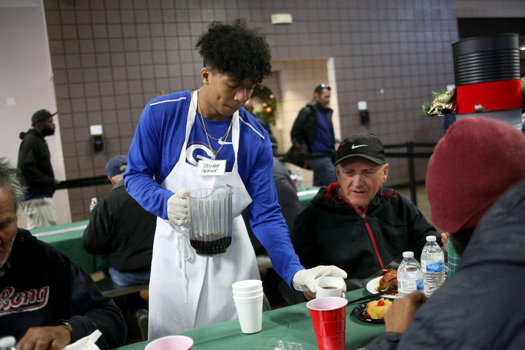 Jovani Hawkins, 17, serves coffee to Ismael Medina at the Christmas meal sponsored by the Frank and Victoria Fertitta Foundation, at Catholic Charities of Southern Nevada in Las Vegas, Sunday, Dec ...