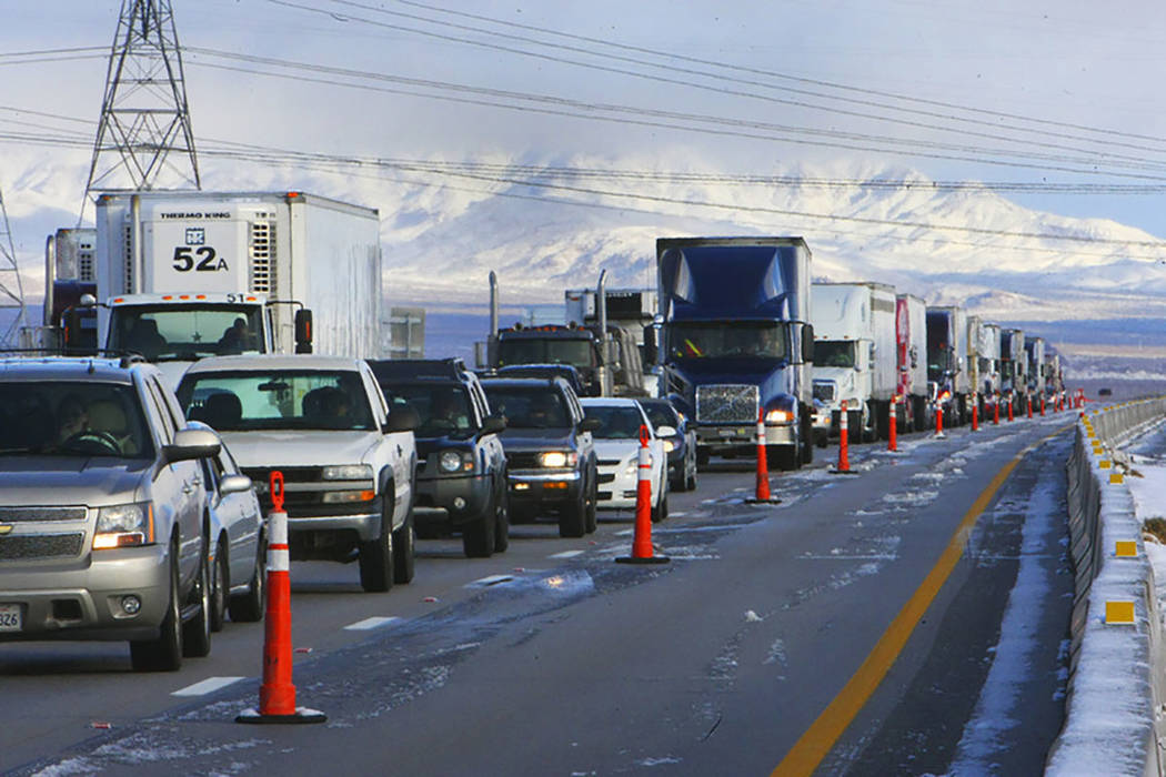 A line of semi tractor-trailers and other vehicles are parked on Interstate 15 in Primm on Dec. ...