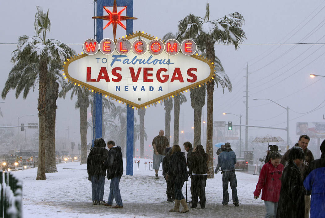 People visit the welcome sign on the Las Vegas Strip to take photos as snow fell in Las Vegas, ...