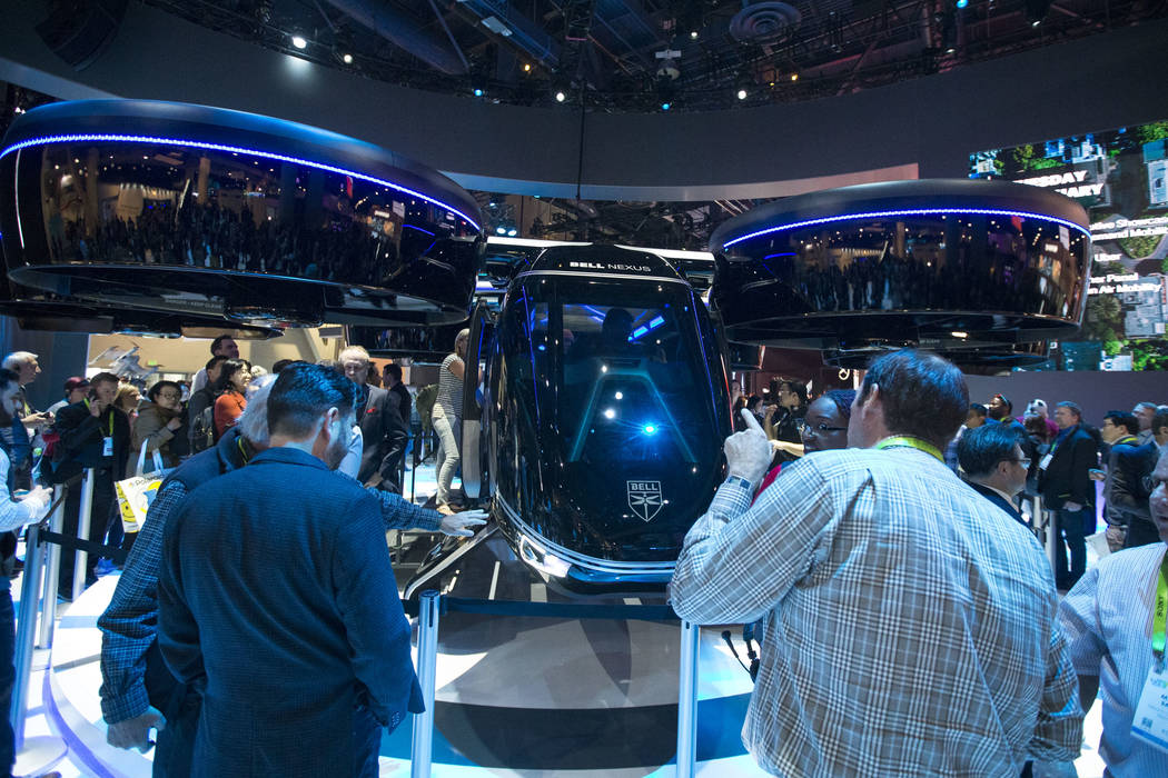 Attendees browse over the Bell Nexus, a hybrid-electric air taxi concept, on display on day one of CES at the Las Vegas Convention Center in Las Vegas on Tuesday, Jan. 8, 2019. Richard Brian Las V ...