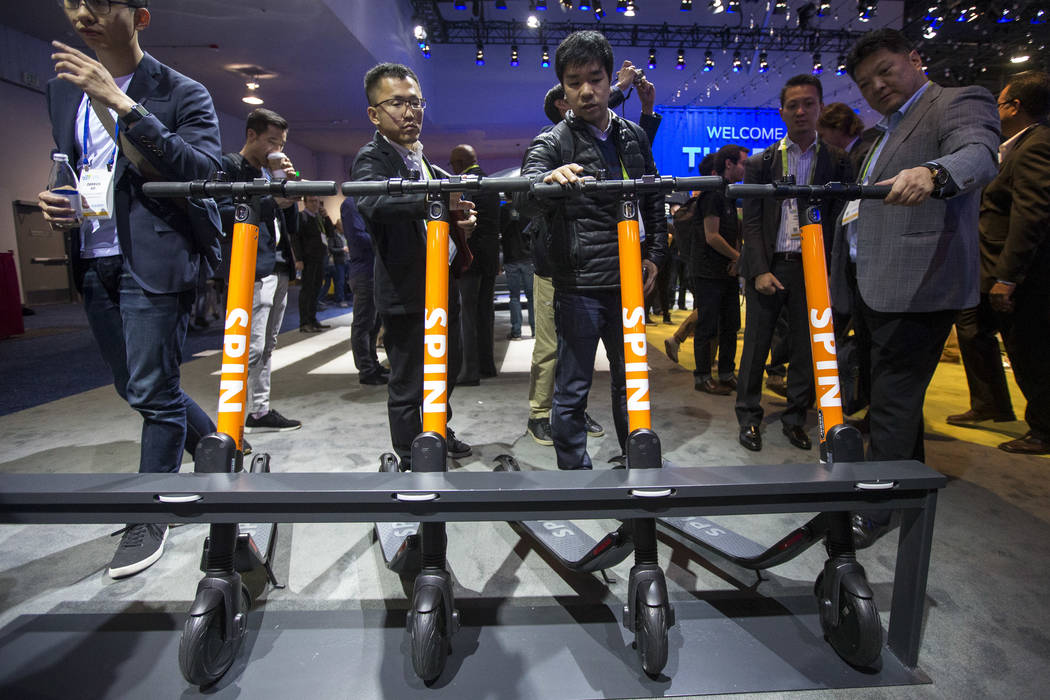 Attendees browse over the Spin electric scooters on display at the Ford Motor Co. booth on day one of CES at the Las Vegas Convention Center in Las Vegas on Tuesday, Jan. 8, 2019. Richard Brian La ...