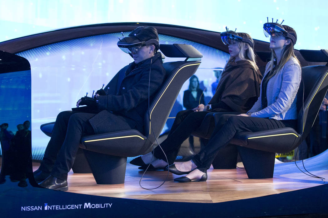 Attendees take part in a demo for autonomous driving innovations at the Nissan Intelligent Mobility booth on day one of CES at the Las Vegas Convention Center in Las Vegas on Tuesday, Jan. 8, 2019 ...