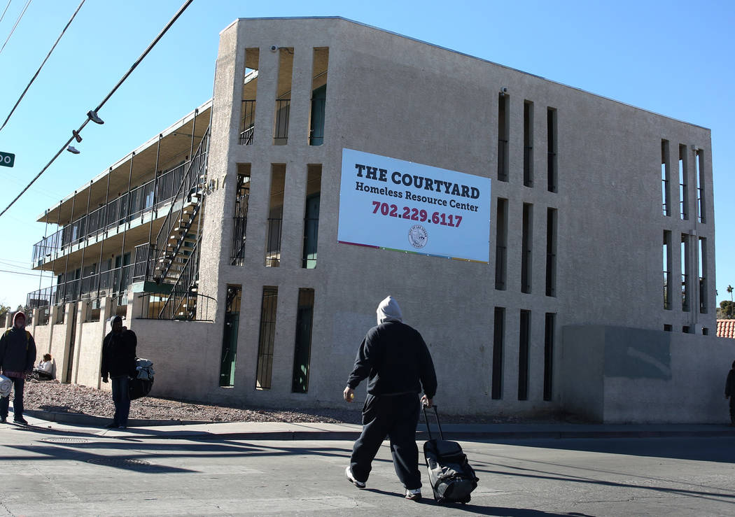 Pedestrians walk past the city of Las Vegasՠhomeless courtyard on Tuesday, Jan. 22, 2019, ...