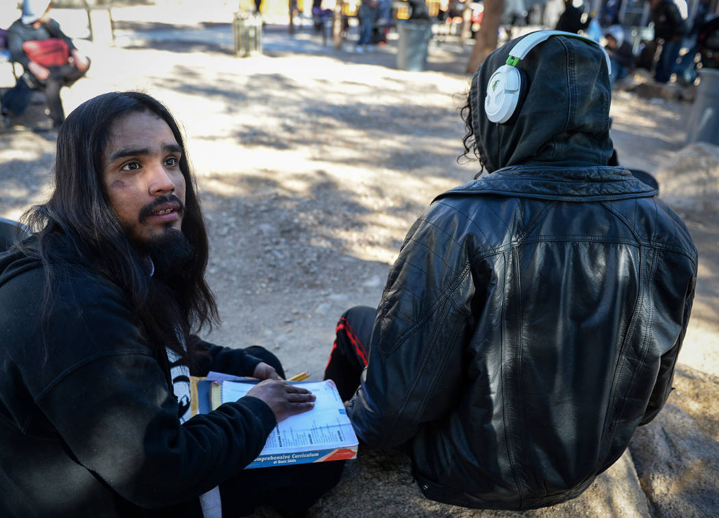 Jaine who declined to give his last name sits with a book he found as he talks about his experi ...