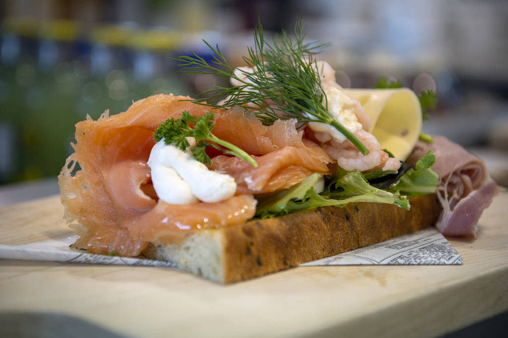 A smoked salmon sandwich is prepared before serving to a customer at Saga Pastry + Sandwich in ...