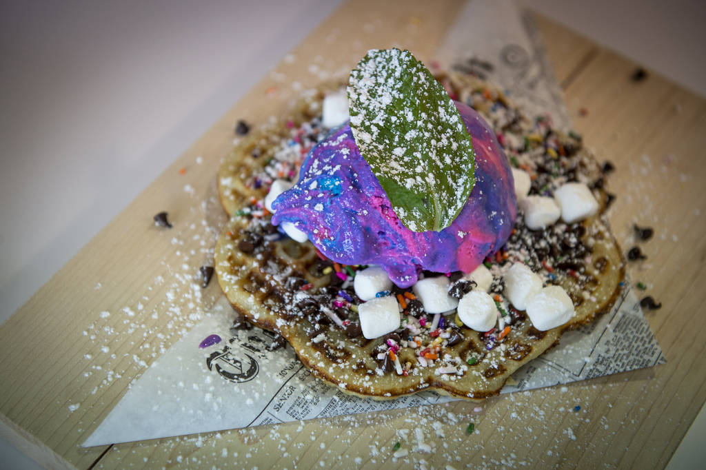 A nordic waffle with ice cream, Nutella, sprinkles, chocolate chips and marshmallows is served ...