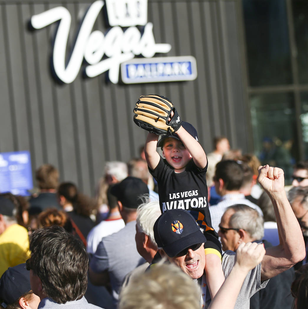 Two-year-old Cooper Enk, sitting on the shoulders of his grandfather, Craig Primas, cheers befo ...