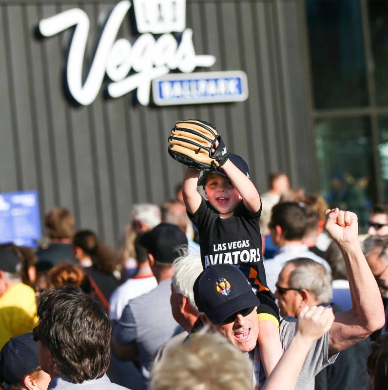 Two-year-old Cooper Enk, sitting on the shoulders of his grandfather, Craig Primas, cheers befo ...