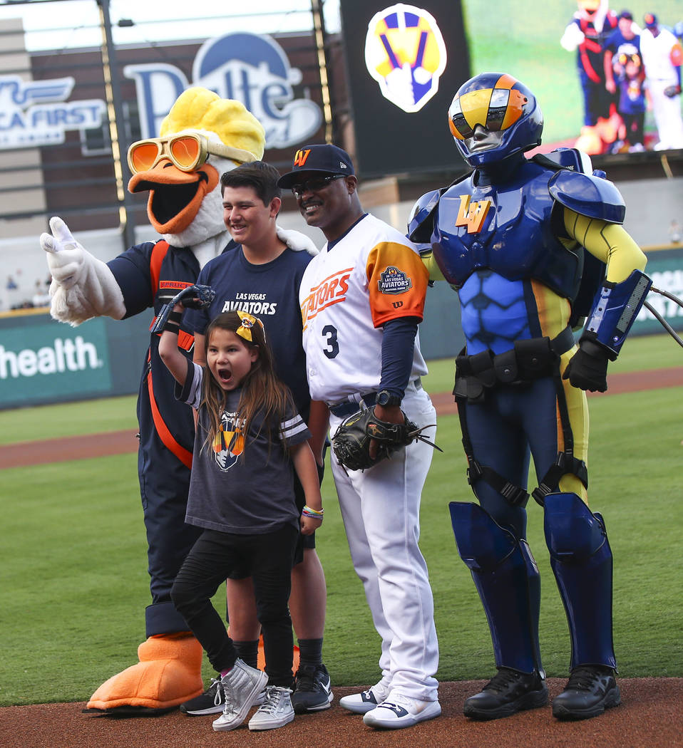 Nine-year-old Hailey Dawson, center, poses after throwing the first pitch with, from left, Spru ...