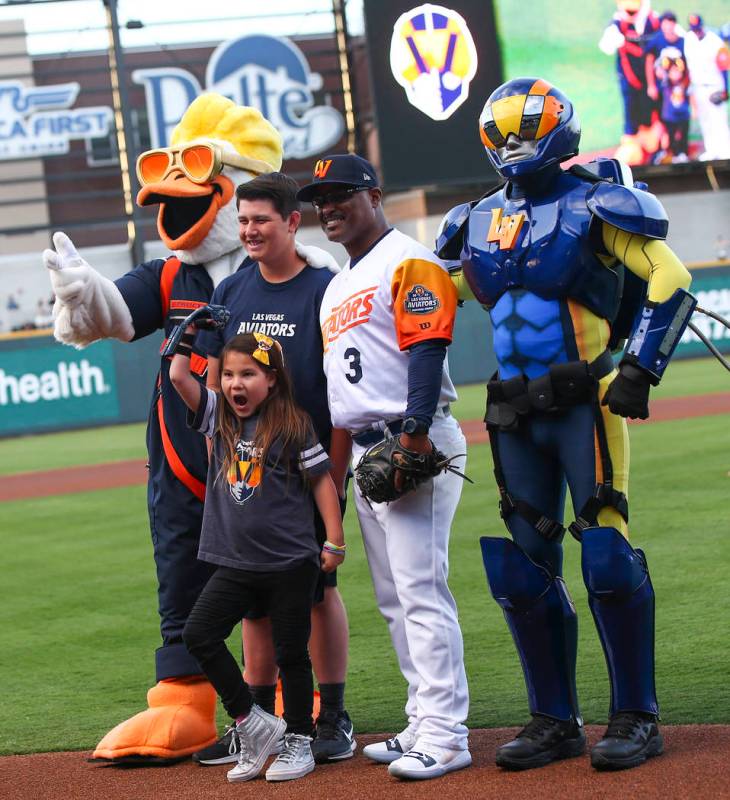 Nine-year-old Hailey Dawson, center, poses after throwing the first pitch with, from left, Spru ...