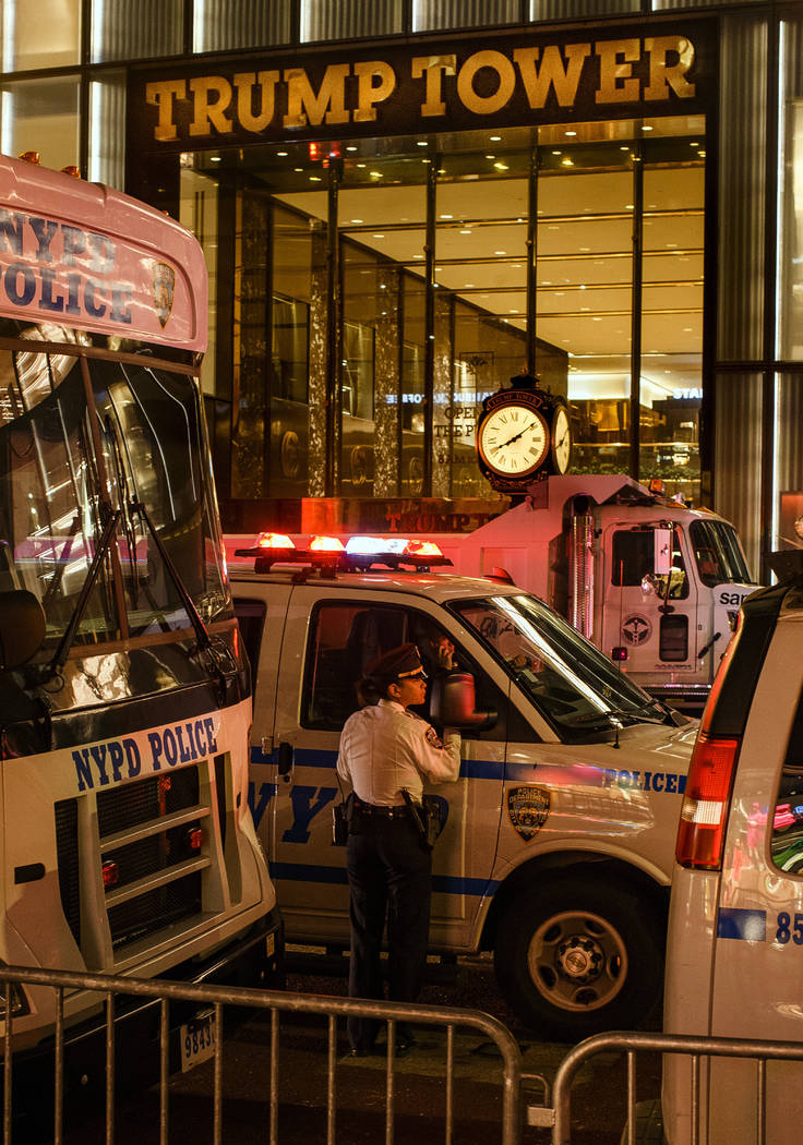 Police stand guard and trucks are parked in front of Trump Tower as a security measure against ...