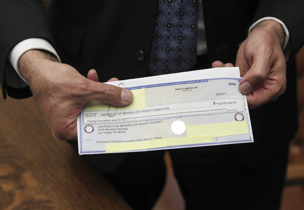 Gov. Brian Sandoval shows the $25,000,000 check from an anonymous donor for the UNLV medical sc ...