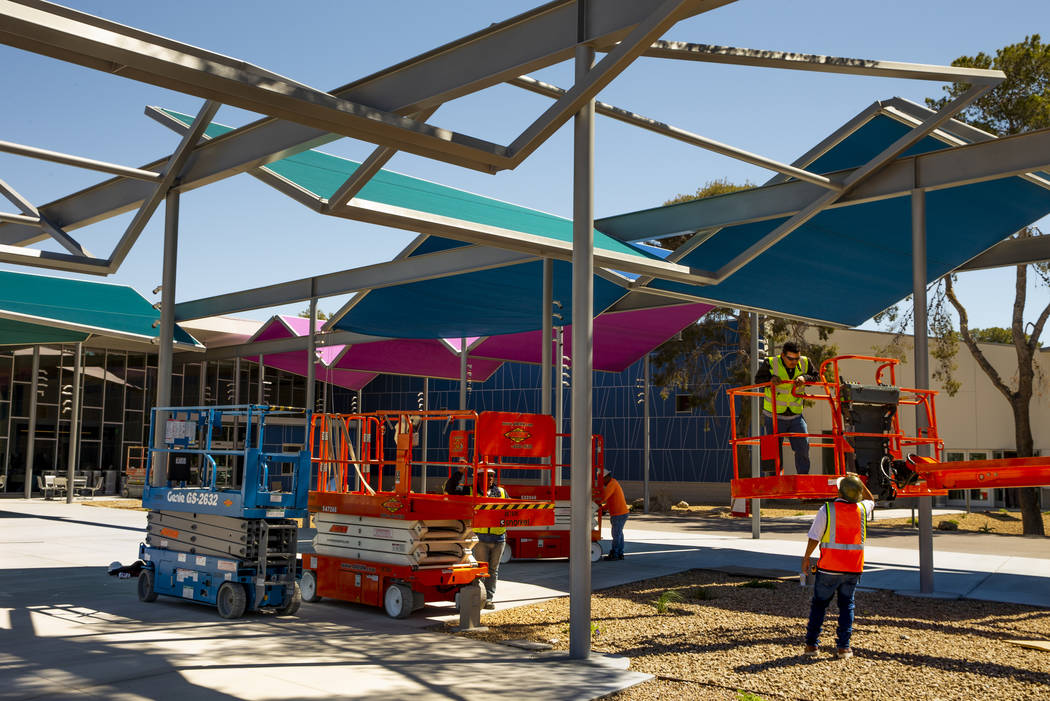 Construction workers continue to hang sails about the patio outside as work continues on the ne ...