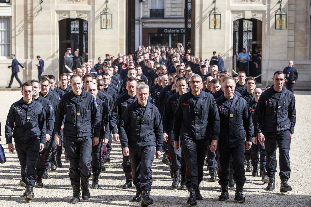 Firefighters and security forces who took part to the fire extinguishing operations at Notre Da ...