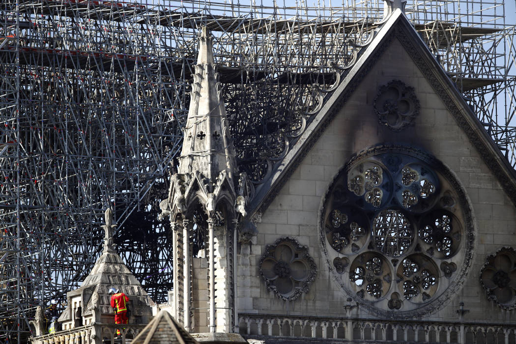 A firefighter makes his way on a balcony of Notre Dame Cathedral Wednesday, April 17, 2019 in P ...