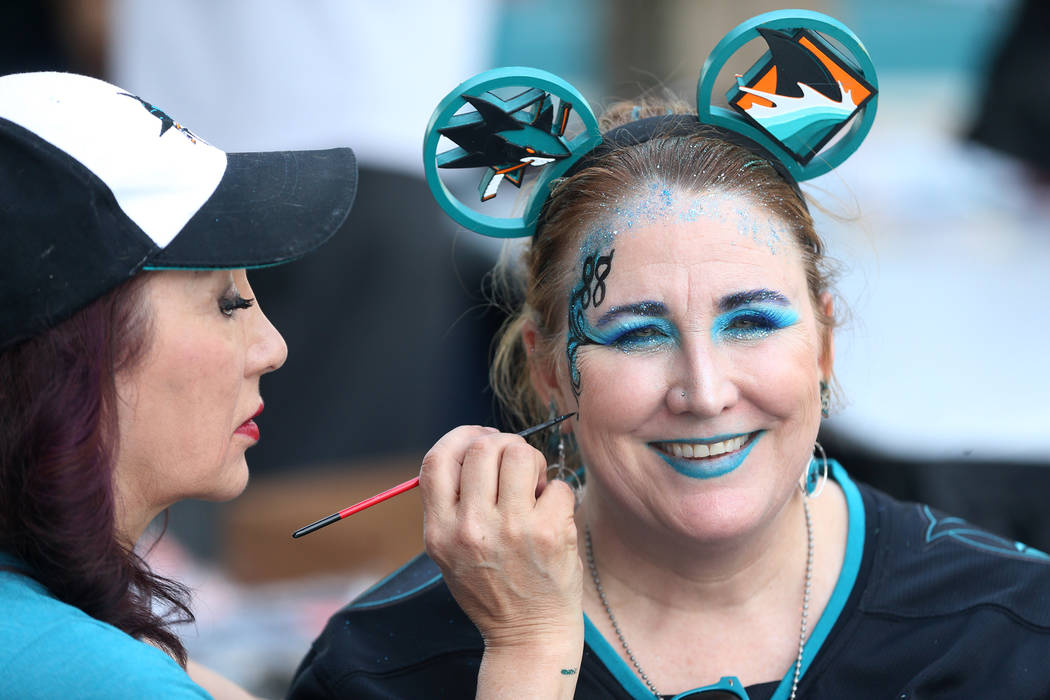 Celeste Oda, left, paints the face of Christie Wendeling, before Game 5 of an NHL Western Confe ...