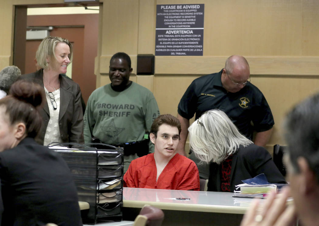 Parkland school shooting suspect Nikolas Cruz speaks with his attorney in court for a defense m ...