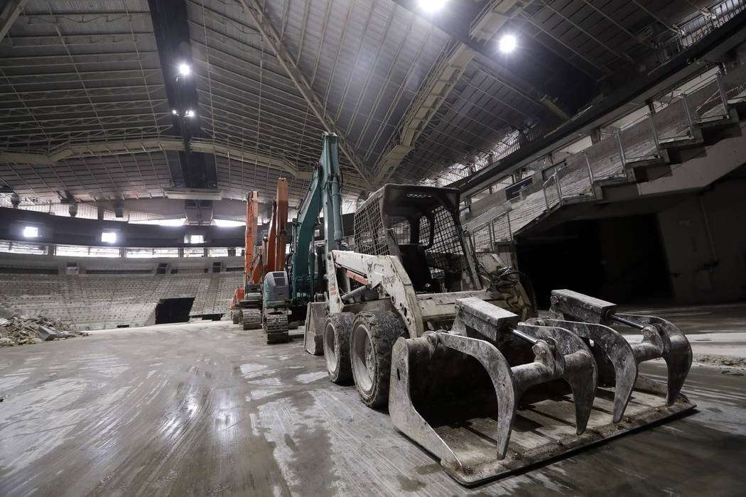 Construction equipment stands on the floor as the interior of the existing roof of KeyArena, th ...