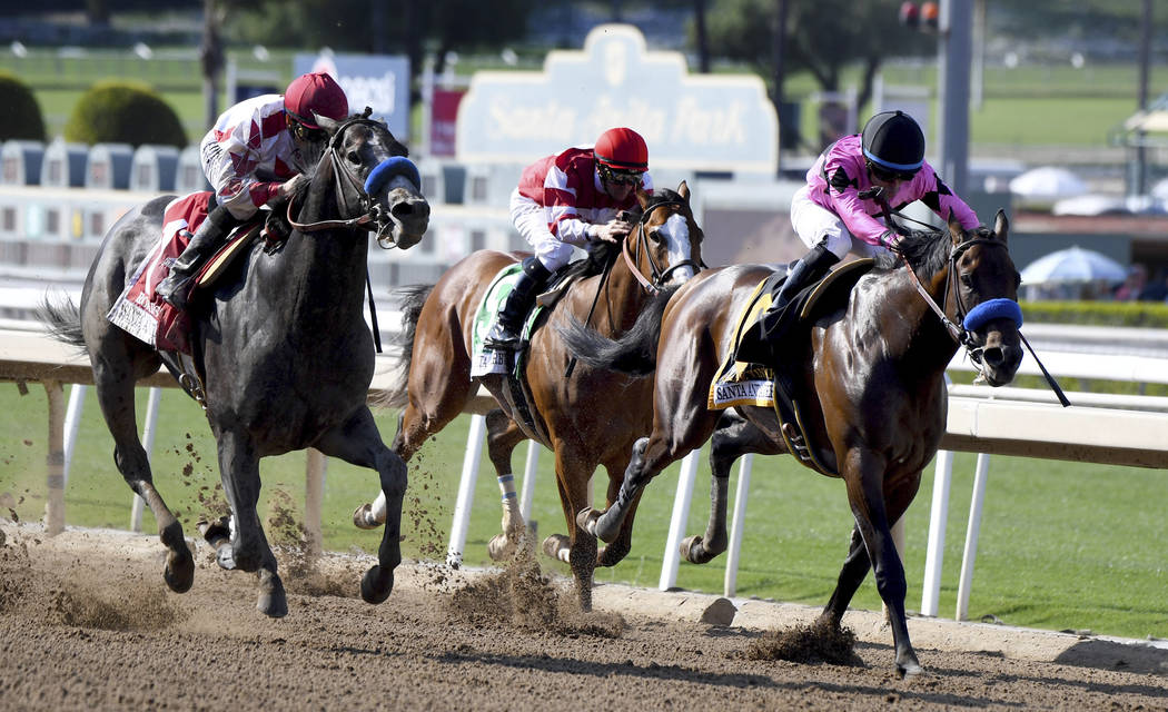 Jockey Mike Smith, left, riding Roadster wins the Santa Anita Derby (Grade 1) race at Santa Ani ...