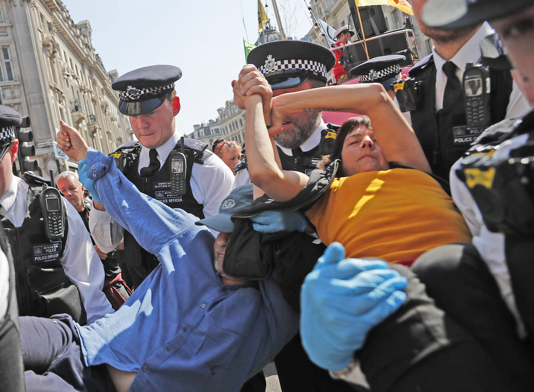 Police arrest a protestor couple who are glued together by their hands, at Oxford Circus in Lon ...