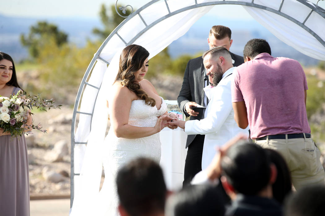 Kimberly and William King exchange rings during their wedding ceremony at the Revere Golf Club ...