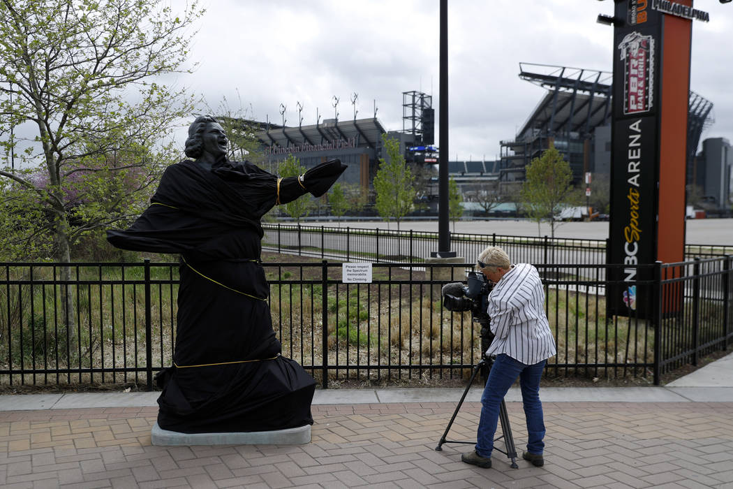 A television photographer records the partially covered statue of singer Kate Smith near the We ...