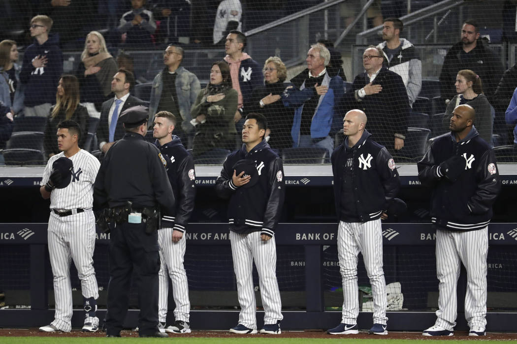 New York Yankees players listen to "God Bless America" during the seventh-inning stretch of the ...