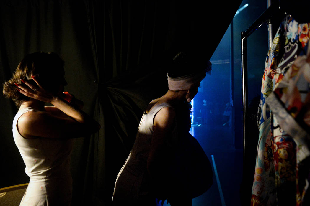 Women wait behind the curtain before going on stage for the fashion show at The Orleans during ...