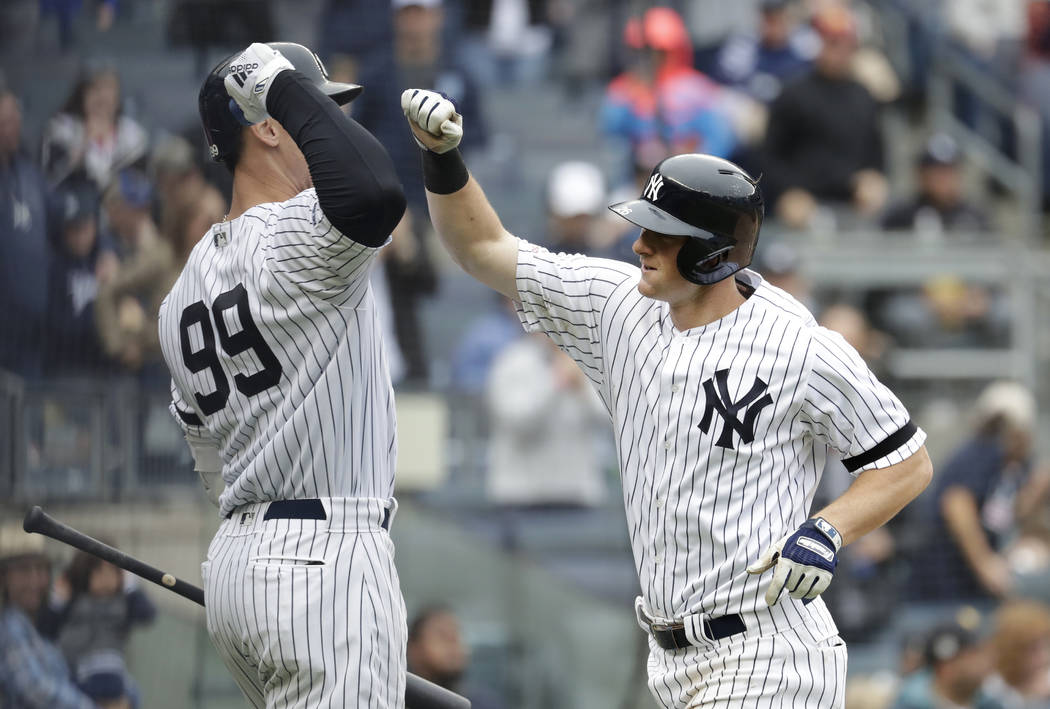 New York Yankees' DJ LeMahieu, right is greeted near the dugout by Aaron Judge (99) after hitti ...