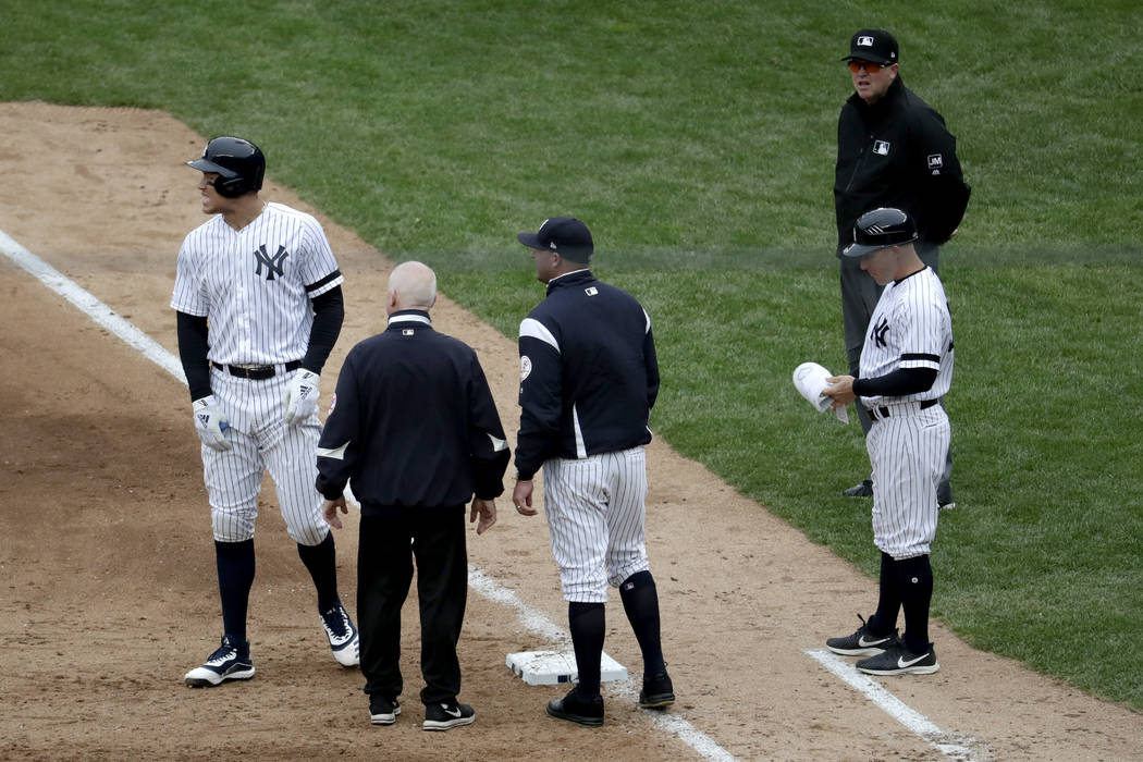 New York Yankees' Aaron Judge, left, reacts while talking to a trainer and bench coach Josh Bar ...