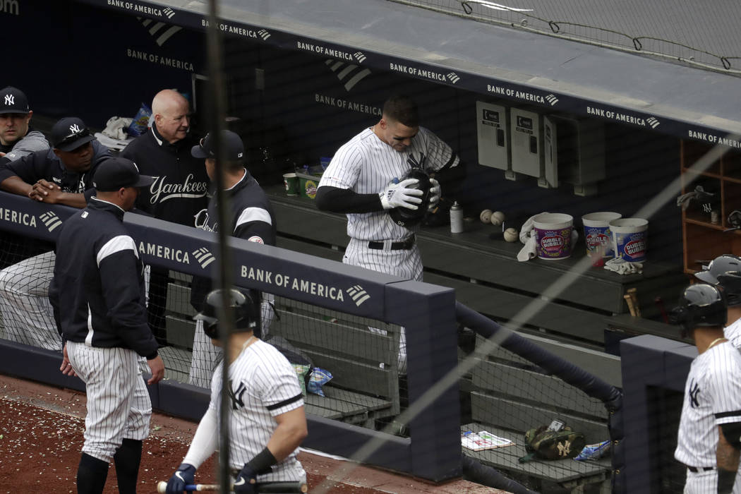 New York Yankees' Aaron Judge, center, clenches his helmet while walking in the dugout after he ...