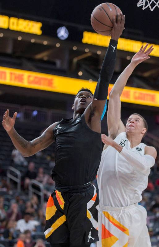 Rocket Watts (1) slices to the rim past Samuell Williamson (10) in the first half during the Jo ...