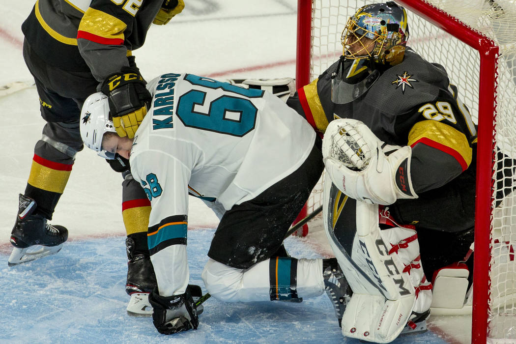 San Jose Sharks center Melker Karlsson (68) is pushed away by Golden Knights goaltender Marc-An ...