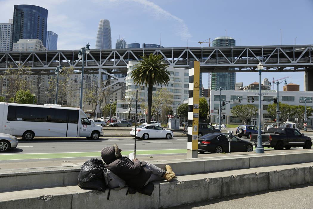 In this Thursday, April 18, 2019 photo, a man rests and reads the Bible while sitting across th ...