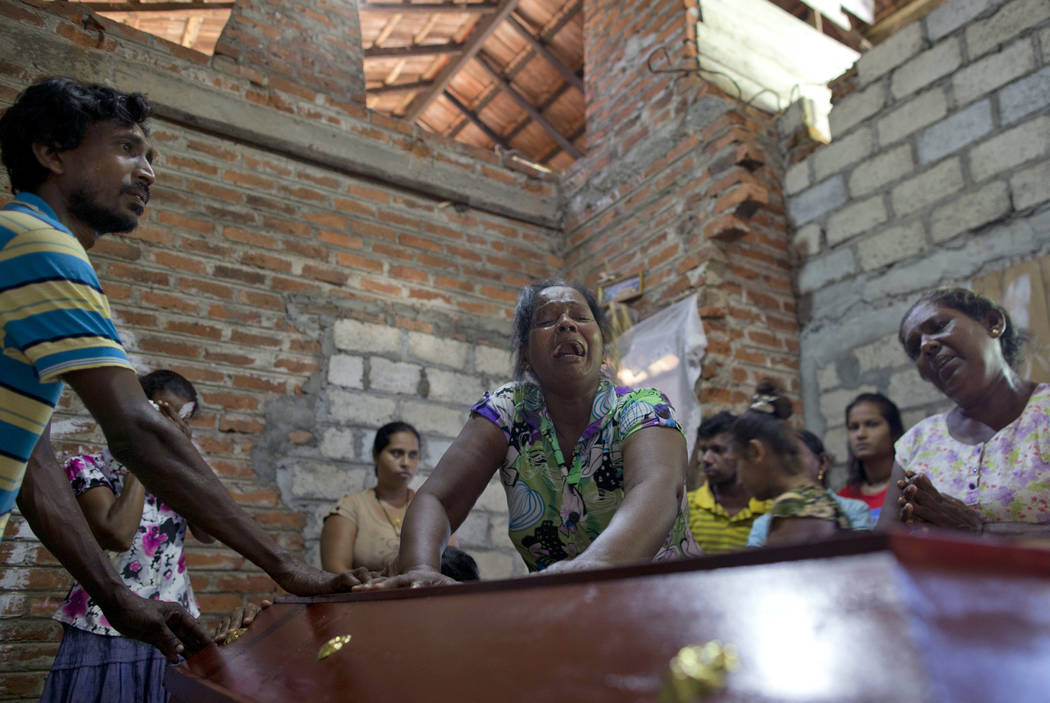 Lalitha, center, weeps over the coffin with the remains of 12-year old niece, Sneha Savindi, wh ...