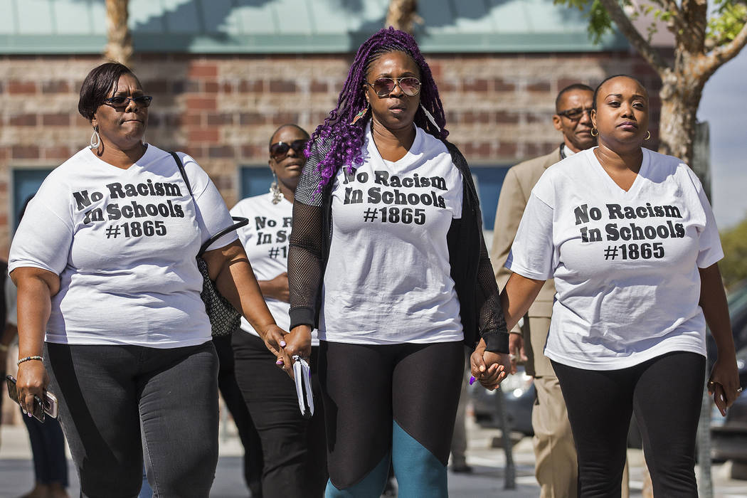 Consuela Nicole, left, Akiko Cooks and Jshauntae Marshall walk hand-in-hand outside the Clark C ...