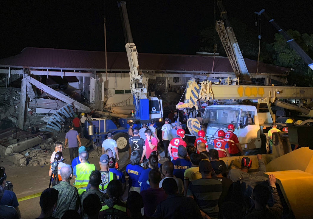 Workers continue rescue efforts on people still trapped inside a collapsed building at Porac to ...