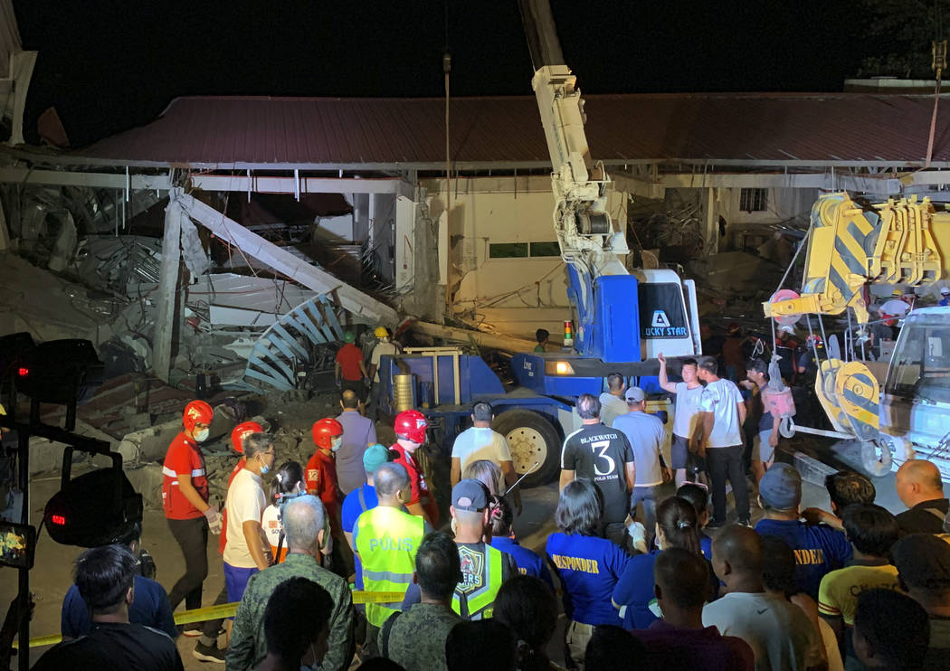 Workers continue rescue efforts on people still trapped inside a collapsed building at Porac to ...