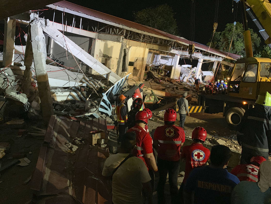 Workers continue rescue operations on people still trapped inside a collapsed building at Porac ...