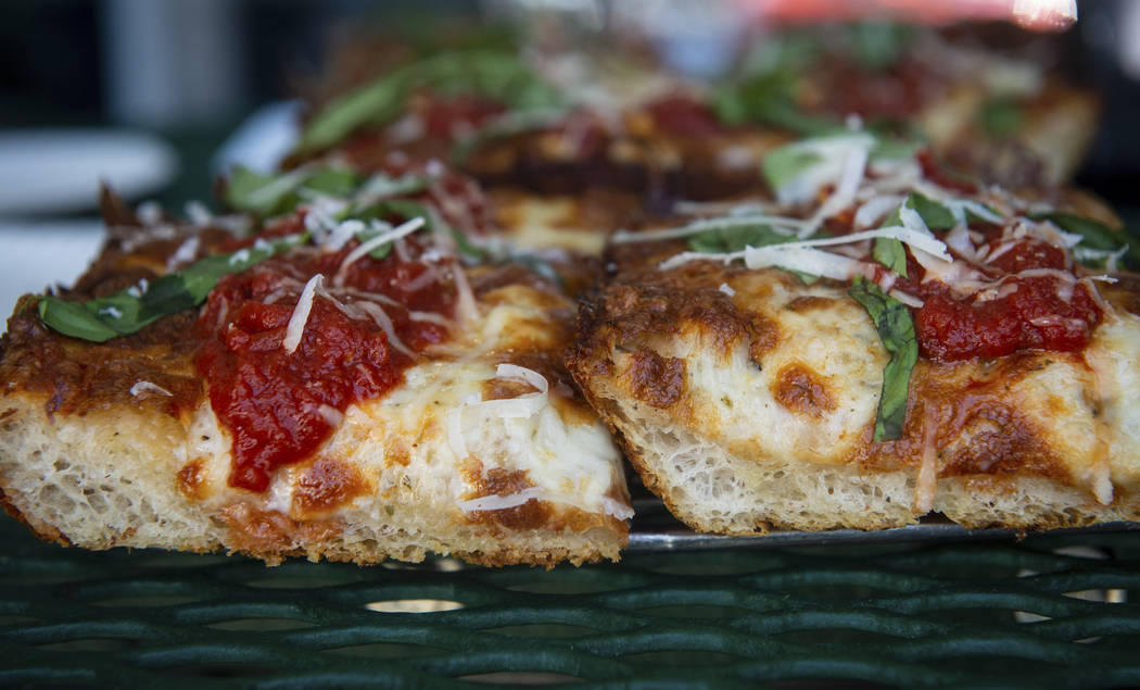 A slice of Detroit-style cheese pizza, left, sits next to a gluten-free slice of Detroit-style ...