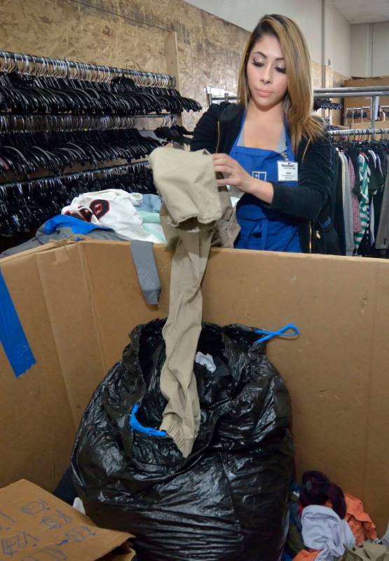 Merchandise processor Jessica Estrada sorts through clothes in the warehouse at the Goodwill Th ...